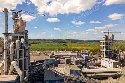 Preview: Aerial view of cement factory with high concrete structure and tower crane at industrial production