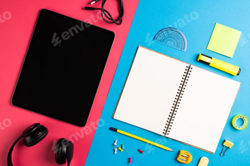 Preview: Composition of tablet and notebook with copy space and school equipment on blue and pink surface