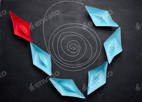 Preview: Multi-colored paper boats follow the leader on a black background.
