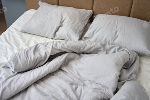 Preview: Crumpled bed with pillows, blanket and crumpled sheets in bedroom
