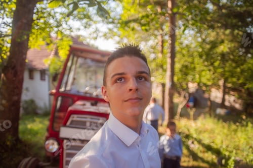 Preview: Little boy in rural area with tractor vehicle in background