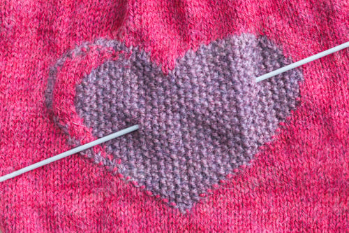 Preview: Knitted fabric with a heart close-up. Valentine's Day. Hobby, handicraft.