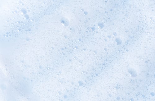 Preview: White foam texture with bubbles. Cosmetic soapy substance with bubbles.