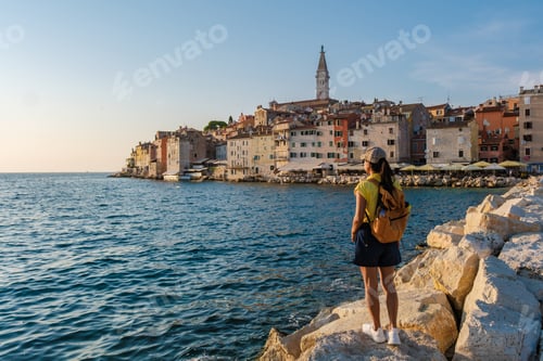 Preview: Evening stroll along the rocky coast of Rovinj, Croatia with vibrant buildings in the background