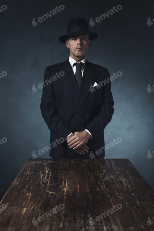 Preview: Bossy Vintage 1940 Businessman Standing Behind Wooden Table.