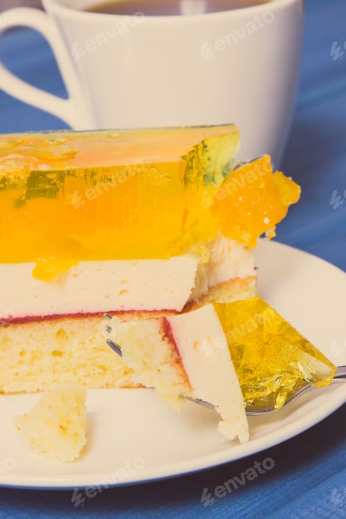 Preview: Homemade creamy fruit cake with jelly and cup of coffee. Delicious dessert for different occasions