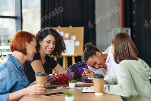 Preview: excited multicultural female friends reading beauty and style magazine and laughing near paper cups