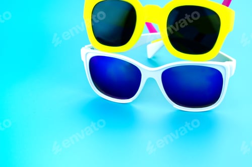 Preview: colorful sunglasses at light blue studio background