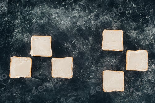 Preview: top view of fresh healthy toasts with butter on black slate board
