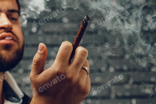 Preview: Bearded man smoking cigar against black brick wall