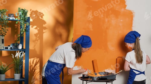 Preview: Mom and girl using orange paint to color interior walls