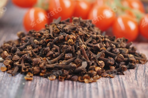 Preview: Cloves on wooden table, cherry tomatoes behind