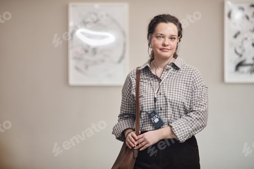 Preview: Portrait of Young Adult Caucasian Woman Wearing Audio Guide Standing Indoors
