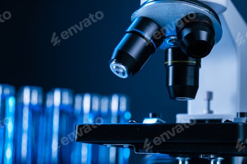 Preview: Close up of laboratory microscope with set of test tubes with blue liquid