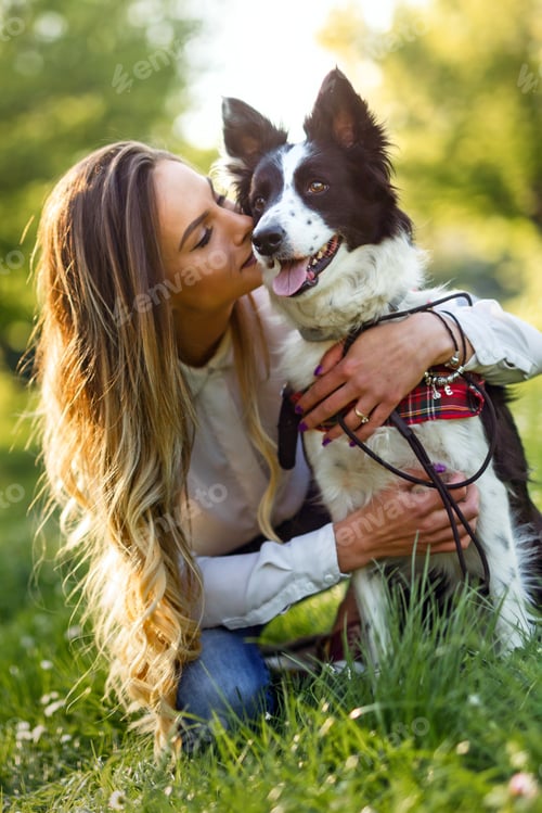 Preview: Beautiful woman walking, playing with a cute dog in nature