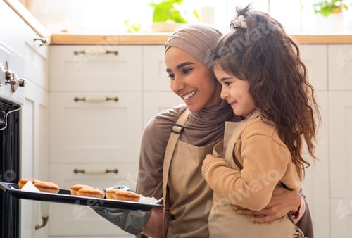 Preview: Beautiful Muslim Mom In Hijab And Her Little Daughter Baking In Kitchen