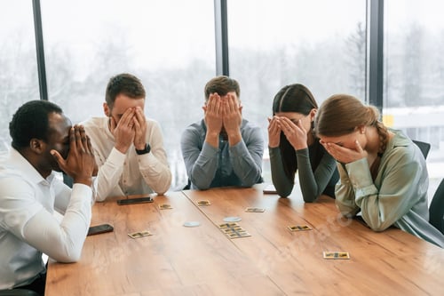 Preview: Covering eyes with hands. Playing card game. Team of office workers are together indoors