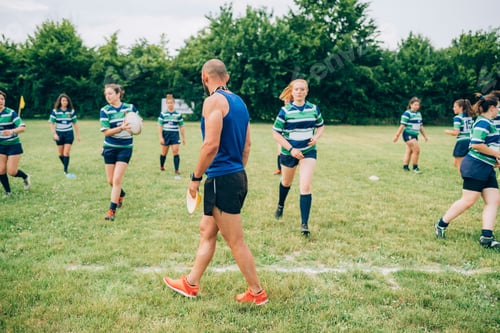 Preview: Coach leading a youth rugby practice session in the park