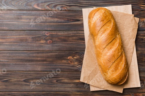 Preview: freshly baked bread with napkin on rustic table top view. Healthy white bread loaf isolated