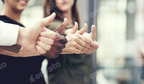 Preview: Closeup shot of a group of businesspeople showing thumbs up together in an office