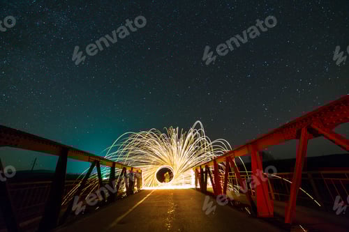 Preview: Light painting art concept. Long exposure shot of spinning steel wool in abstract circle