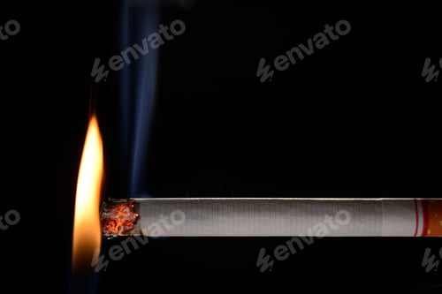 Preview: Cigarette being lit by small flame on black background