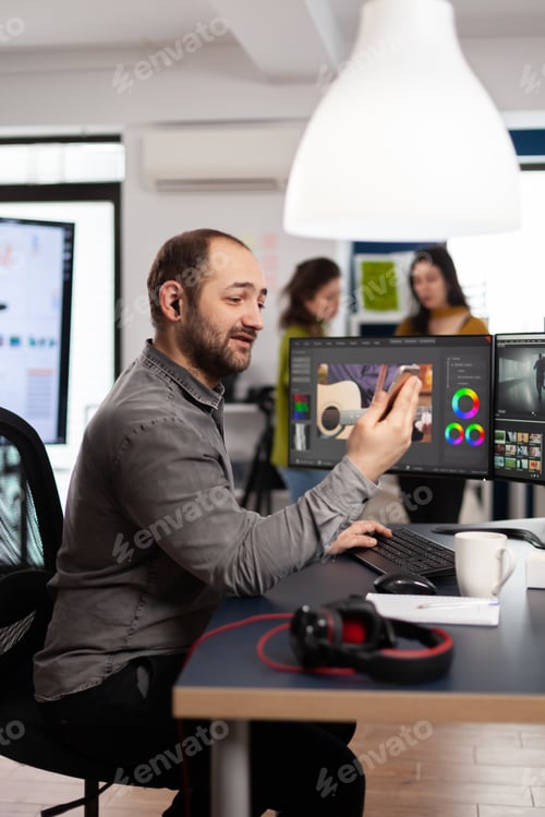 Preview: Videographer discussing online with customer holding smartphone