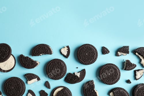 Preview: Tasty chocolate cookies with cream on color background, flat lay. Space for text