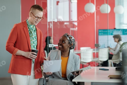 Preview: Colleagues Discussing Work while Reviewing Documents in Office