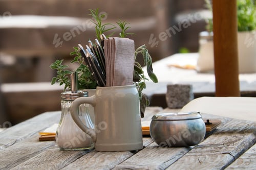 Preview: Laid table on a terrace, with, cutlery, ashtray, sugar shaker and menu