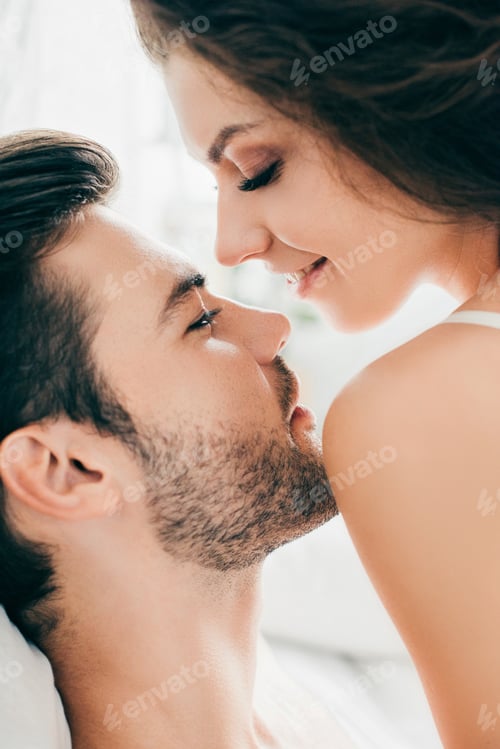 Preview: close-up view of sensual happy young couple able to kiss in foreplay