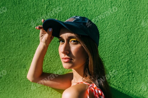 Preview: Portrait of brunette girl with long hair and cap looking at camera