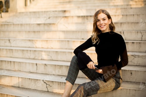Preview: Smiling Woman Sitting on Steps in Sunlight