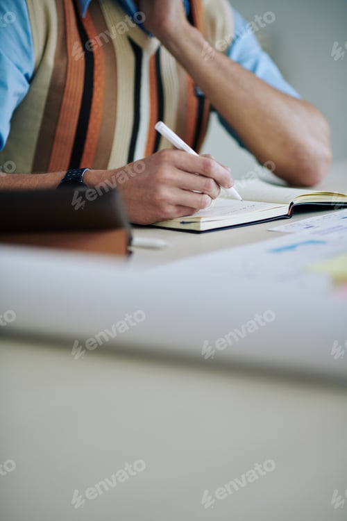 Preview: Businessman filling planner