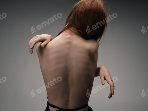 Preview: Nude woman touches herself with hands on a light background model cropped view