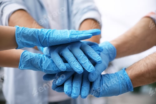 Preview: Group of people in blue medical gloves stacking hands indoors, closeup