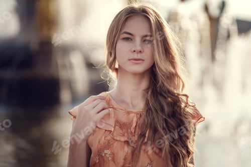 Preview: young woman, against background of summer green park, green leaves