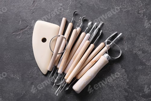 Preview: Set of different clay crafting tools on grey table, top view