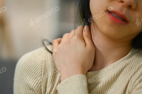 Preview: Cropped shot of young woman massaging her neck suffering from ache. Health care and problem concept