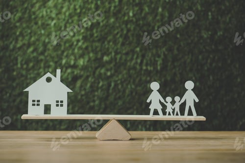 Preview: paper cut house and paper family balancing on seesaw on green background