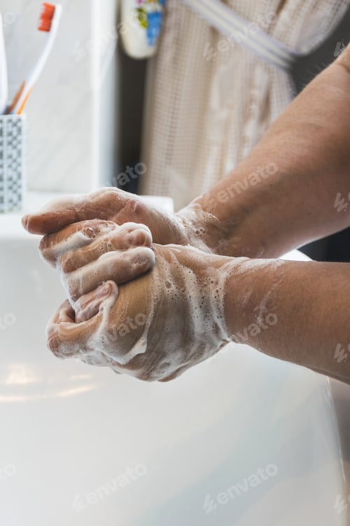 Preview: Vertical shot of a male washing his hands with foamy soap- COVID-19, coronavirus concept