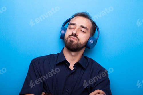 Preview: Young man listening to music through headphones