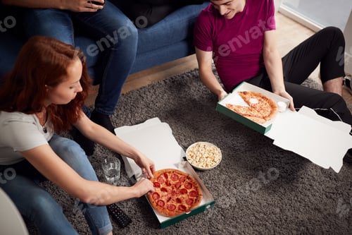 Preview: Group Of College Students In Shared House Having Night In Eating Pizza Together