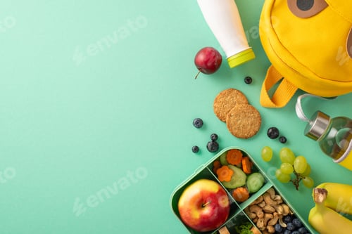 Preview: School lunchbox with healthy goodies. Top view of eco-friendly container brimming