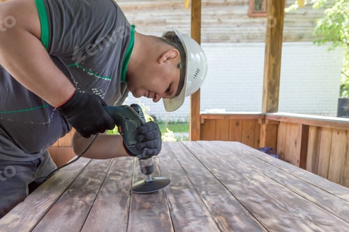 Preview: Male hands close up. Sanding a wooden table before varnishing