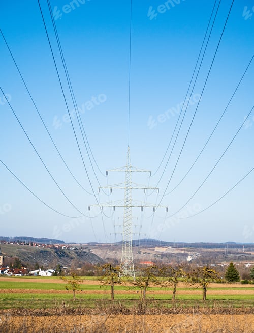 Preview: Vertical shot of a transmission tower in the field under a
