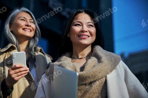 Preview: Two beautiful cheerful women standing on the street