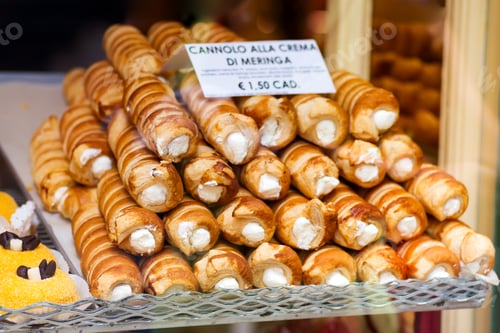 Preview: Closeup of cannoli stuffed with cream cheese whipped filling dessert on tray window display in