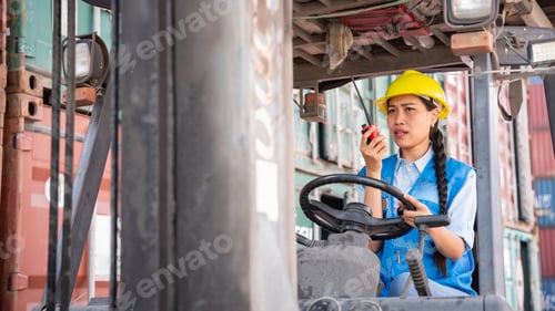 Preview: Engineer or foreman working and use talkie with a forklift in at container yard.