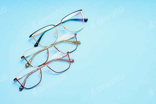 Preview: pair of red plastic-rimmed eyeglasses on a blue background